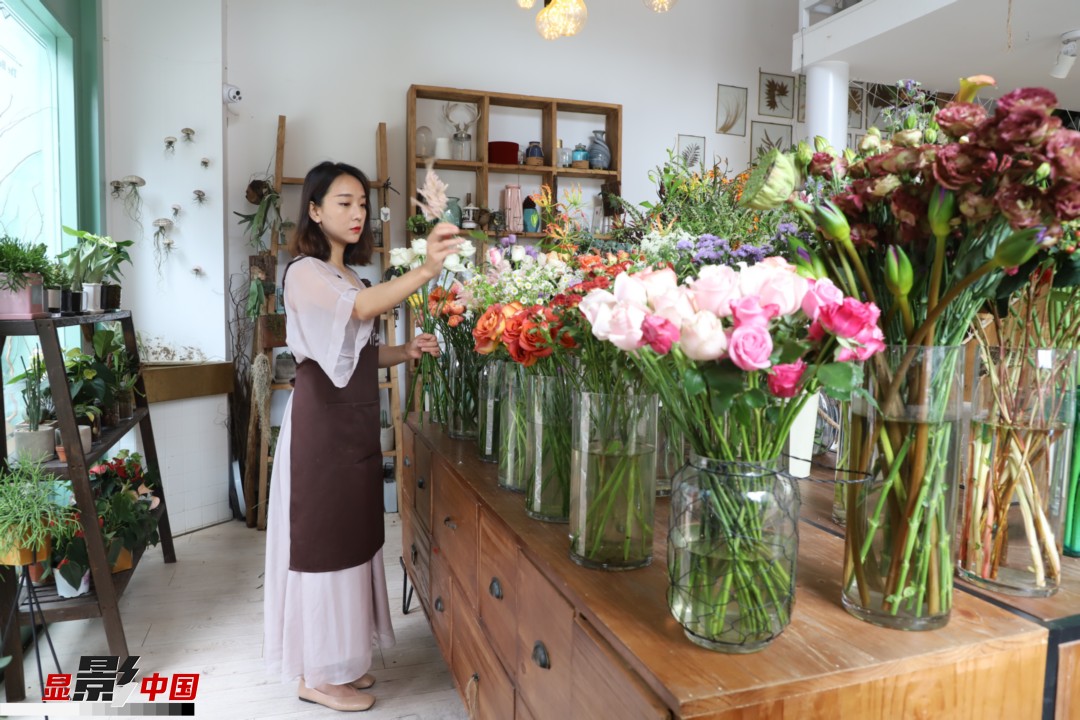 王黎媛是一名河南姑娘，在昆明念完大學(xué)后，就再也舍不下春城的藍(lán)天陽(yáng)光、青山碧水，更舍不下這里的四時(shí)繁花，于是就干脆留了下來(lái)，成了一名媒體人。2017年的時(shí)候又毅然辭去工作，創(chuàng)業(yè)開(kāi)起了花店，成了都市里的一名“花房姑娘”。圖為王黎媛在自己的花店中整理鮮花。新華網(wǎng) 周亞平/攝 念新洪/文